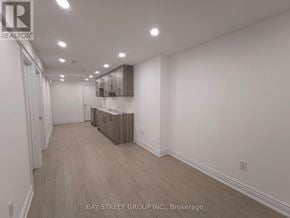 Vaughan (Patterson) apartment for rent - A spacious room with wooden flooring and white walls.