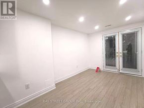 Vaughan (Patterson) apartment for rent - A room with a white wall and a wooden floor with a door on the right side.