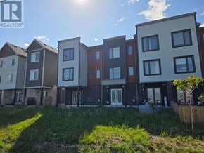 Barrie townhouse for rent - A row of modern townhouses with a grassy area in front.