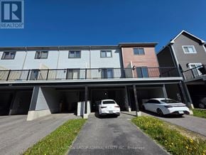 Barrie townhouse for rent - A row of townhouses with cars parked in front.