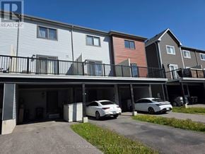 Barrie townhouse for rent - A row of townhouses with cars parked in the garages.