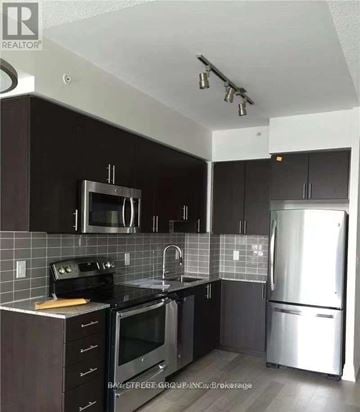 Markham (Thornhill) condo for rent - A kitchen with a black counter top and stainless steel appliances.