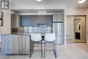 Markham (Unionville) condo for rent - A modern kitchen with a bar area and two white chairs.