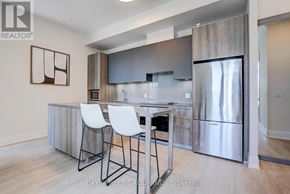 Markham (Unionville) condo for rent - A modern kitchen with a bar area and white chairs.