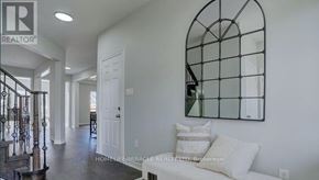 Clarington (Bowmanville) apartment for rent - A living room with a white couch and a mirror on the wall.