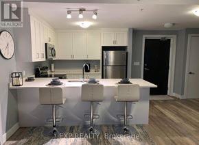 St. Catharines (Ridley) condo for rent - A modern kitchen with white cabinets and a central island.