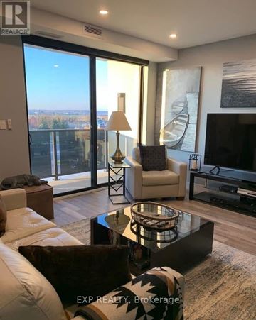 St. Catharines (Ridley) condo for rent - A living room with a glass table and a white sofa.
