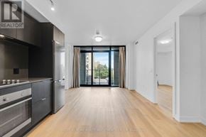 Hamilton (Beasley) condo for rent - A spacious kitchen with wooden floors and a large window.