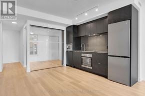 Hamilton (Beasley) condo for rent - A modern kitchen with dark cabinets and a wooden floor.