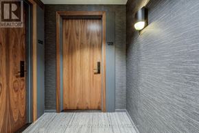 Toronto (Yonge-St. Clair) condo for rent - A wooden door with a glass panel is flanked by two wooden doors with numbers on them.