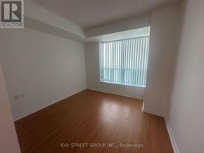 Toronto (Willowdale East) condo for rent - A room with wooden flooring and a window with blinds.