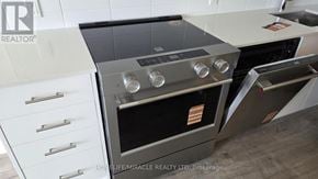 Vaughan (Vellore Village) condo for rent - A modern kitchen with a stainless steel oven and white cabinetry.