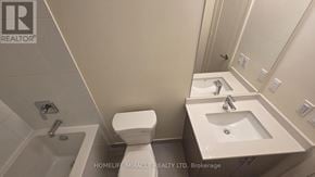 Vaughan (Vellore Village) condo for rent - A white toilet sits next to a sink in a bathroom.