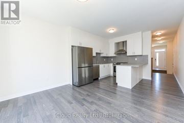 Oakville (Go Glenorchy) townhouse for rent - A spacious kitchen with white cabinets and a central island.