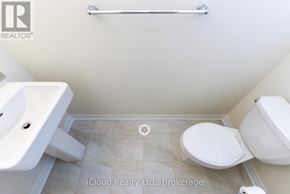 Oakville (Go Glenorchy) townhouse for rent - A white toilet sits in a bathroom with a white sink and a towel bar on the wall.