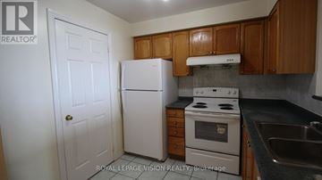 Toronto (Agincourt North) condo for rent - A white refrigerator and stove in a kitchen with wooden cabinets.