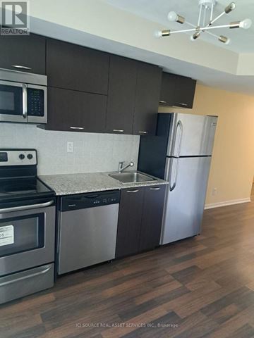 Toronto (South Parkdale) condo for rent - A kitchen with a stainless steel refrigerator and microwave.
