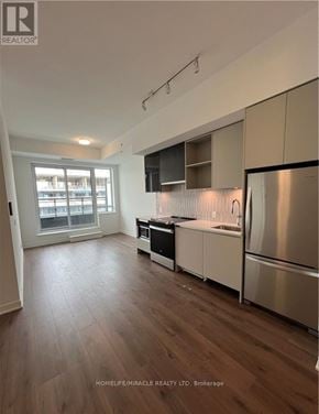 Oakville (Go Glenorchy) condo for rent - A kitchen with a refrigerator, sink, and stove.