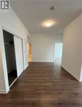 Oakville (Go Glenorchy) condo for rent - A room with wooden flooring and white walls, with a door on the left and a window on the right.