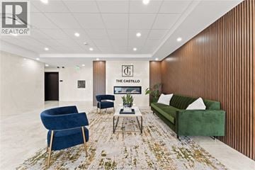 Windsor condo for rent - A living room with a green couch, blue armchair, and a coffee table.
