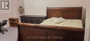 Toronto (Willowdale East) apartment for rent - A bed with a wooden headboard and footboard with a mattress on top of it.