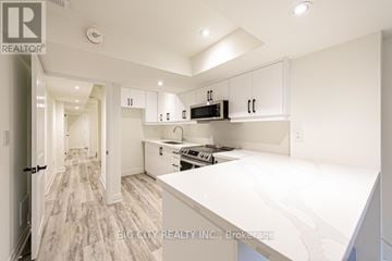 Georgina (Keswick South) apartment for rent - A white kitchen with a stove top oven and microwave.