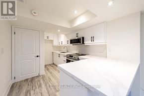 Georgina (Keswick South) apartment for rent - A white kitchen with a white door and white cabinets.