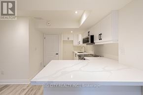 Georgina (Keswick South) apartment for rent - A white kitchen with a counter top and cabinets.