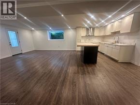 Hamilton apartment for rent - A large empty room with wooden flooring and white walls.