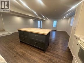 Hamilton apartment for rent - A large, empty room with a wooden table and dark wood flooring.