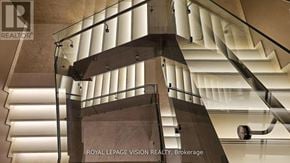Mississauga (Hurontario) condo for rent - A staircase with a glass railing and white steps.