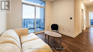 Mississauga (Hurontario) condo for rent - A living room with a white sofa and a round table with a black chair.