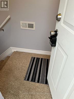 Oshawa (Donevan) apartment for rent - A door with a black handle and a striped rug on the floor.