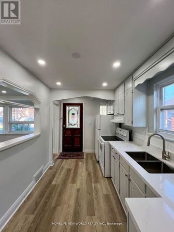 Toronto (Keelesdale-Eglinton West) apartment for rent - A kitchen with white cabinets and a wooden floor.