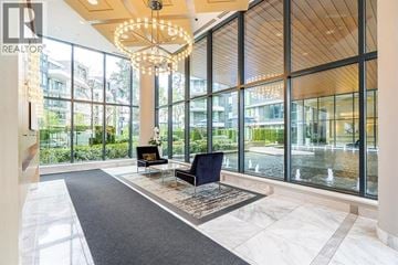 Vancouver apartment for rent - A large, modern living room with a black sofa and a chandelier.