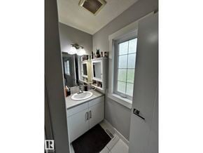 Edmonton apartment for rent - A bathroom with a sink, mirror, and a window.
