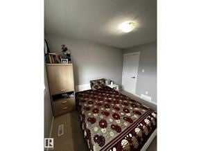 Edmonton apartment for rent - A bedroom with a bed, dresser, and nightstand.