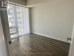 Toronto (Waterfront Communities) condo for rent - A room with wooden flooring and a sliding glass door.