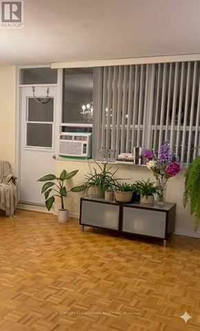 Toronto (L'amoreaux) condo for rent - A room with a wooden floor and a window with blinds.
