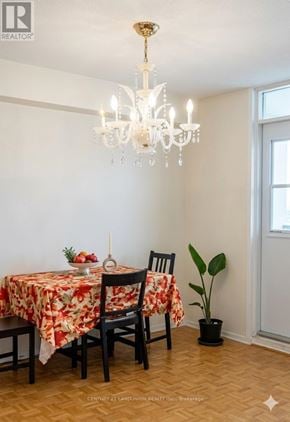 Toronto (L'amoreaux) condo for rent - A dining room with a table set for two and a chandelier hanging from the ceiling.