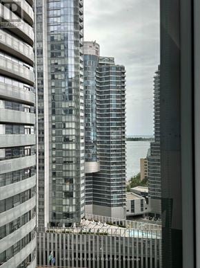 Toronto (Waterfront Communities) condo for rent - A view of a cityscape with tall buildings and a body of water in the distance.