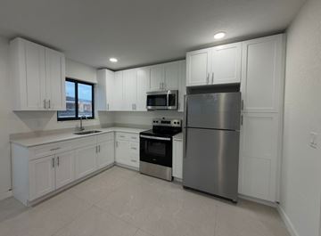 Hialeah apartment for rent - A kitchen with white cabinets and stainless steel appliances.