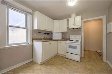 London apartment for rent - A kitchen with white appliances and cabinets.