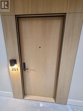 Toronto (Englemount-Lawrence) condo for rent - A wooden door with the number 201 on it.