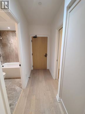 Toronto (Englemount-Lawrence) condo for rent - A hallway with a wooden door and a white wall.