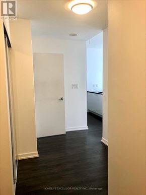Toronto (Henry Farm) condo for rent - A hallway with a white door and wooden floors.