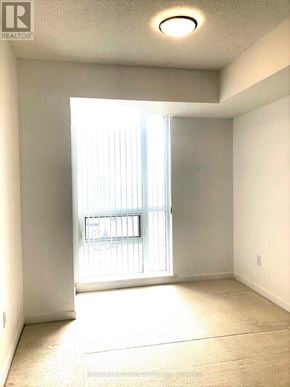 Toronto (Henry Farm) condo for rent - A well lit empty room with a window and a door.