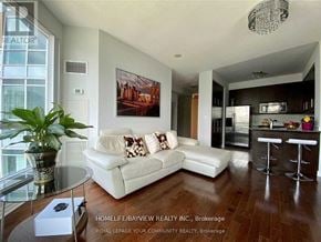 Toronto (Willowdale East) condo for rent - A living room with a white couch and a painting on the wall.