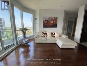 Toronto (Willowdale East) condo for rent - A living room with a white couch and a large window.