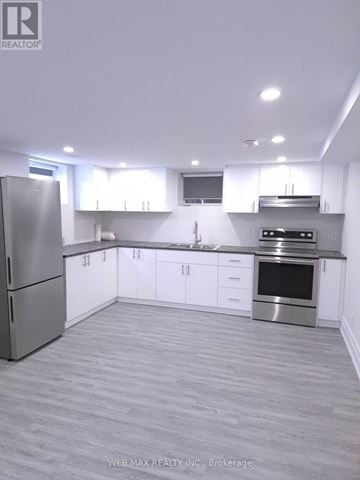 Toronto (Dorset Park) apartment for rent - A modern kitchen with white cabinets and stainless steel appliances.